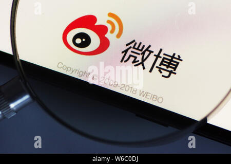 --FILE--A Chinese netizen looks at a logo of Weibo, the Twitter-like microblogging service of Chinese Internet portal Sina, on his smartphone in Ji'na Stock Photo