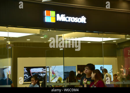--FILE--Pedestrians walk past a store of Microsoft in Daxing district, Beijing, China, 29 April 2018.   The United States tech giant Microsoft Corp is Stock Photo