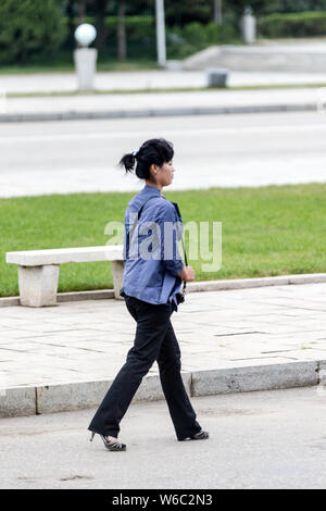 --FILE--A North Korean woman wearing high heels walks on the street in Pyongyang, North Korea, 30 August 2016. Stock Photo