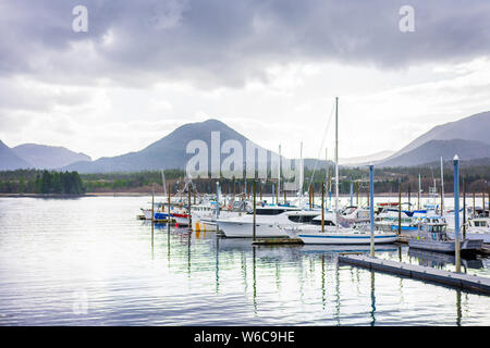 Fishing boats sit docked in rugged mountain terrain of Ketchikan Alaska Stock Photo