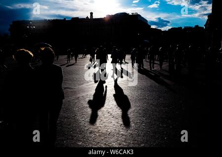 Silhouettes of people walking on the streets during sunset Stock Photo ...