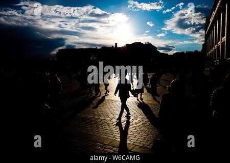 Silhouettes of people walking on the streets during sunset Stock Photo ...
