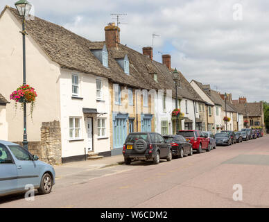 Cars parked on street frontage outside historic building in Saxon town of Cricklade, Wiltshire, England, Uk Stock Photo