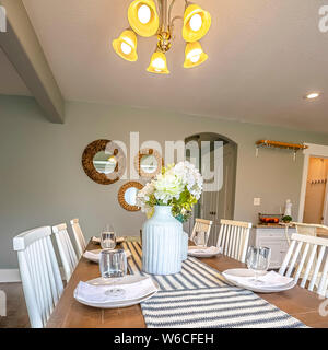 Square frame Dining room interior of a home with brown wooden table and white chairs Stock Photo