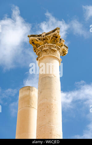 Corinthian style columns made of marble against blue sky with picturesque clouds Stock Photo