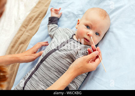 Mother cleaning nose to adorable baby Stock Photo