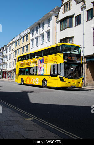 Oxford, United Kingdom - June 29 2019:   A Yellow City3 Oxford bus tavelling in bright sunshine along High Street Stock Photo