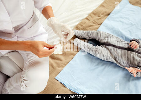 Nurse and newborn baby on bed Stock Photo