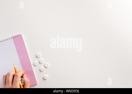 Male hand writing in the notebook. Medical concept. Flat lay. Stock Photo