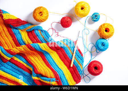 Multi-colored striped crochet, crochet hook and yarn. Handwork, hobby. Close-up, top view. Stock Photo