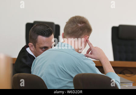 Kempten, Germany. 01st Aug, 2019. A 22-year-old is sitting in the bar next to his lawyer Werner Hamm (l). Because he wanted to take revenge on his ex-girlfriend, who had separated a few weeks ago, the young man is said to have brutally beaten to death his son, who was only eight months old. Since today (01.08.2019) the father has to answer for murder before the district court of Kempten. Credit: Karl-Josef Hildenbrand/dpa/Alamy Live News Stock Photo