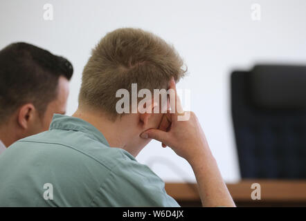 Kempten, Germany. 01st Aug, 2019. A 22-year-old is sitting in the bar next to his lawyer Werner Hamm (l). Because he wanted to take revenge on his ex-girlfriend, who had separated a few weeks ago, the young man is said to have brutally beaten to death his son, who was only eight months old. Since today (01.08.2019) the father has to answer for murder before the district court of Kempten. Credit: Karl-Josef Hildenbrand/dpa/Alamy Live News Stock Photo