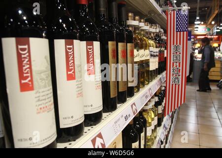 --FILE--Bottles of Dynasty red wine are for sale next to wines imported from the United States at a supermarket in Xuchang city, central China's Henan Stock Photo