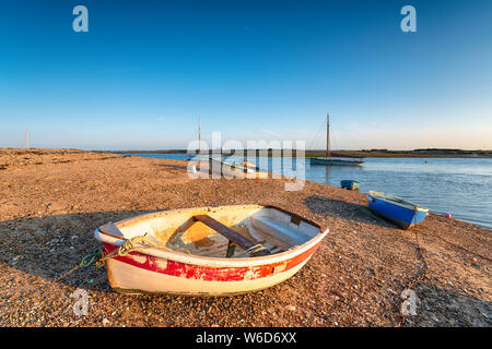 Boats under a clear blue sky on the beach at West Mersea on the Essex coast Stock Photo