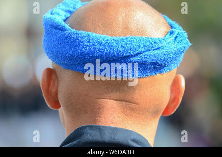 A festival participant in Japan with a blue towel wrapped around his head. Stock Photo