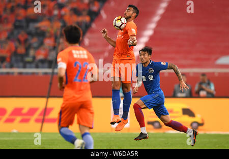 Graziano Pelle of Shandong Luneng stops the ball by the chest during ...