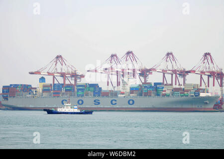 --FILE--A cargo ship of COSCO Shipping loaded with containers to be shipped abroad berths on a quay at the Port of Qingdao city, east China's Shandong Stock Photo