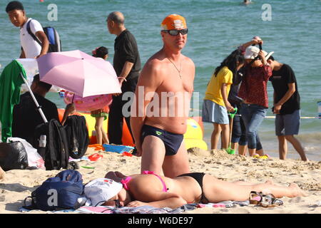 --FILE--Foreign and domestic tourists enjoy themselves on a beach resort in Sanya city, south China's Hainan province, 22 February 2018.   China will Stock Photo