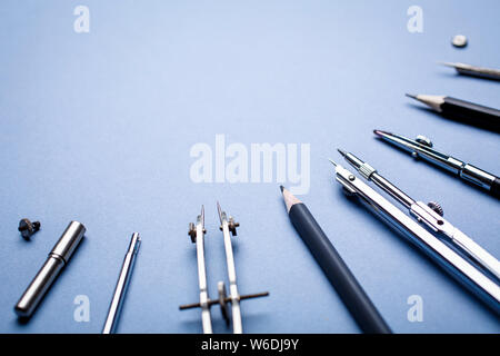 Tools for drawing blueprints laid out in a semicircle on a blue background Stock Photo