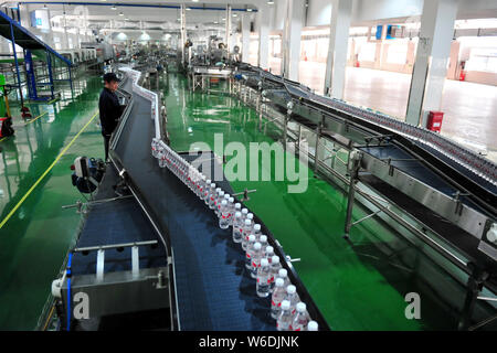 --FILE--A Chinese worker checks bottles of Wahaha purified water on the ...