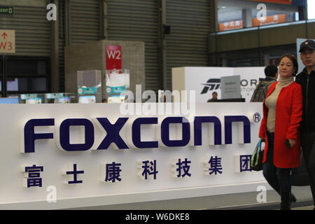 --FILE--Visitors walk past the stand of Foxconn during an exhibition in Shanghai, China, 11 March 2018.   Electronics manufacturing giant Foxconn Tech Stock Photo