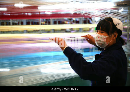 --FILE--A female Chinese worker handles production of yarn to be exported at a textile factory in Yangxin county, Binzhou city, east China's Shandong Stock Photo