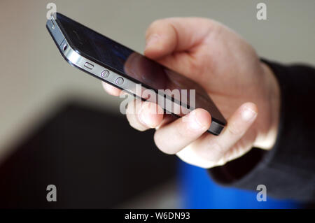 --FILE--A Chinese mobile phone user uses his iPhone smartphone in Ji'nan city, east China's Shandong province, 16 March 2018.   China's telecommunicat Stock Photo