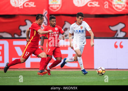 Brazilian football player Oscar, right, of Shanghai SIPG challenges Tan
