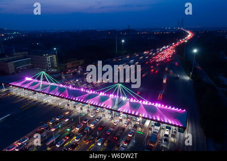 In this aerial view, masses of vehicles queue up to pass through a toll