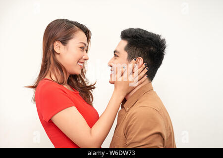 Handsome man picking up and hugging his girlfriend isolated on white background Stock Photo