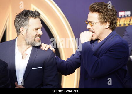 (From left) American actor and singer Robert Downey Jr. and English actor Tom Hiddleston pose as they arrive on the red carpet of a promotional event