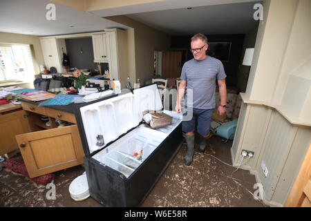 Martin Ward inspecting flood damage in his house after it was flooded in Cheshire, after heavy rainfall caused severe flooding on Wednesday. Stock Photo