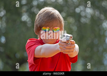 boy aiming with toy pistol, Freiberg, Bayerischer Wald, Bavaria, Germany Stock Photo