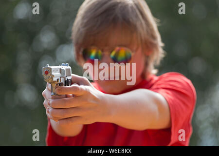 boy aiming with toy pistol, Freiberg, Bayerischer Wald, Bavaria, Germany Stock Photo