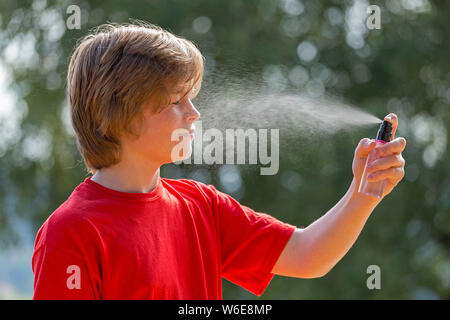 boy spraying water into his face, Freiberg, Bayerischer Wald, Bavaria, Germany Stock Photo