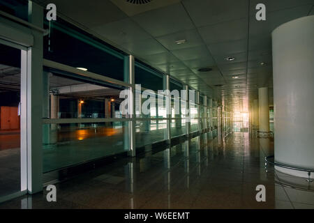 Empty modern international airport hall with sunset sunlight on background. Stock Photo