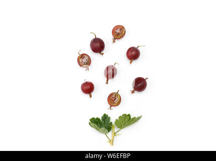 Organic ripe red gooseberries. Whole berries and halves with a sprig. Creative layout made of  gooseberries isolated on white. Flat lay. Stock Photo