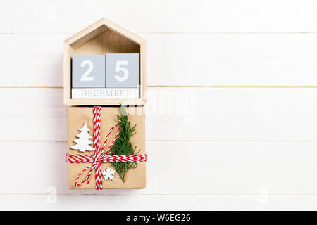 Christmas calendar 1 december. Christmas gift, fir branches on wooden white background. Copy space, top view. Stock Photo