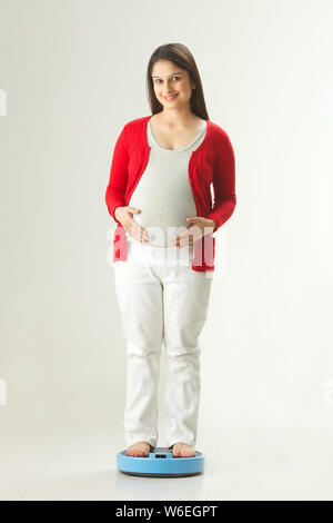 Pregnant woman weighing herself Stock Photo