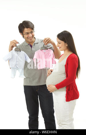 Young man showing baby clothes to his wife Stock Photo