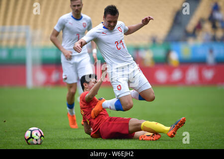 A player of Chinese national men's football team challenges Stanislav Tecl of Czech Republic national football team in their final match to fight for Stock Photo