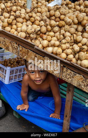 A Little Boy Hides Under A Potato Stall, Carbon Market, Cebu City, Cebu, The Philippines Stock Photo