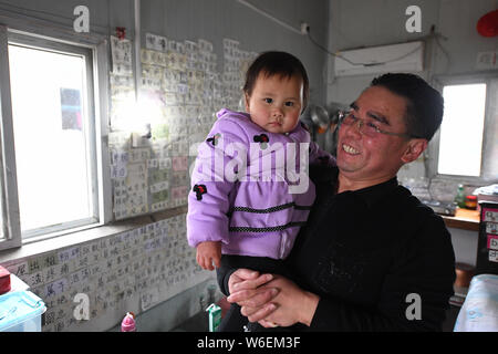 Two-year-old Chinese prodigy named 'He Meiqi' reads characters posted on the wall accompanied by her father at home in Hefei city, east China's Anhui Stock Photo