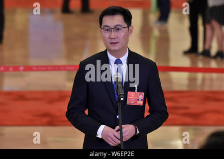 Pony Ma Huateng, Chairman and CEO of Tencent Holdings Ltd., is interviewed as he arrives at the 'deputy passage' before the opening meeting for the Fi Stock Photo