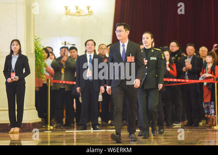 Pony Ma Huateng, front, Chairman and CEO of Tencent Holdings Ltd., is interviewed as he arrives at the 'deputy passage' before the opening meeting for Stock Photo