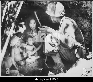 A member of a Marine patrol on Saipan found this family of Japs hiding in a hillside cave. The mother, four children and a dog, took shelter from the fierce fighting in that area., 06/21/1944 Stock Photo