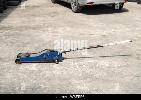 Used hydraulic vehicle jack or vehicle lifting for inspection of vehicle underbody, brake repairs. Stock Photo