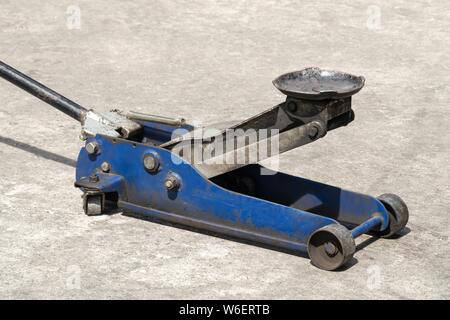 Used hydraulic vehicle jack or vehicle lifting for inspection of vehicle underbody, brake repairs. Stock Photo