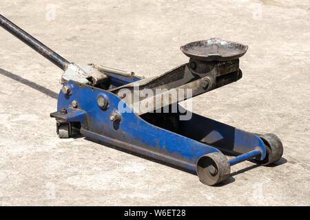 Used hydraulic vehicle jack or vehicle lifting for inspection of vehicle underbody, brake repairs. Stock Photo