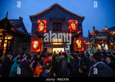 Visitors watch 60-year-old Chinese folk artist Chen Shouke performing shadow play or shadow puppetry, also known as shadow puppet, in Tai'erzhuang dis Stock Photo